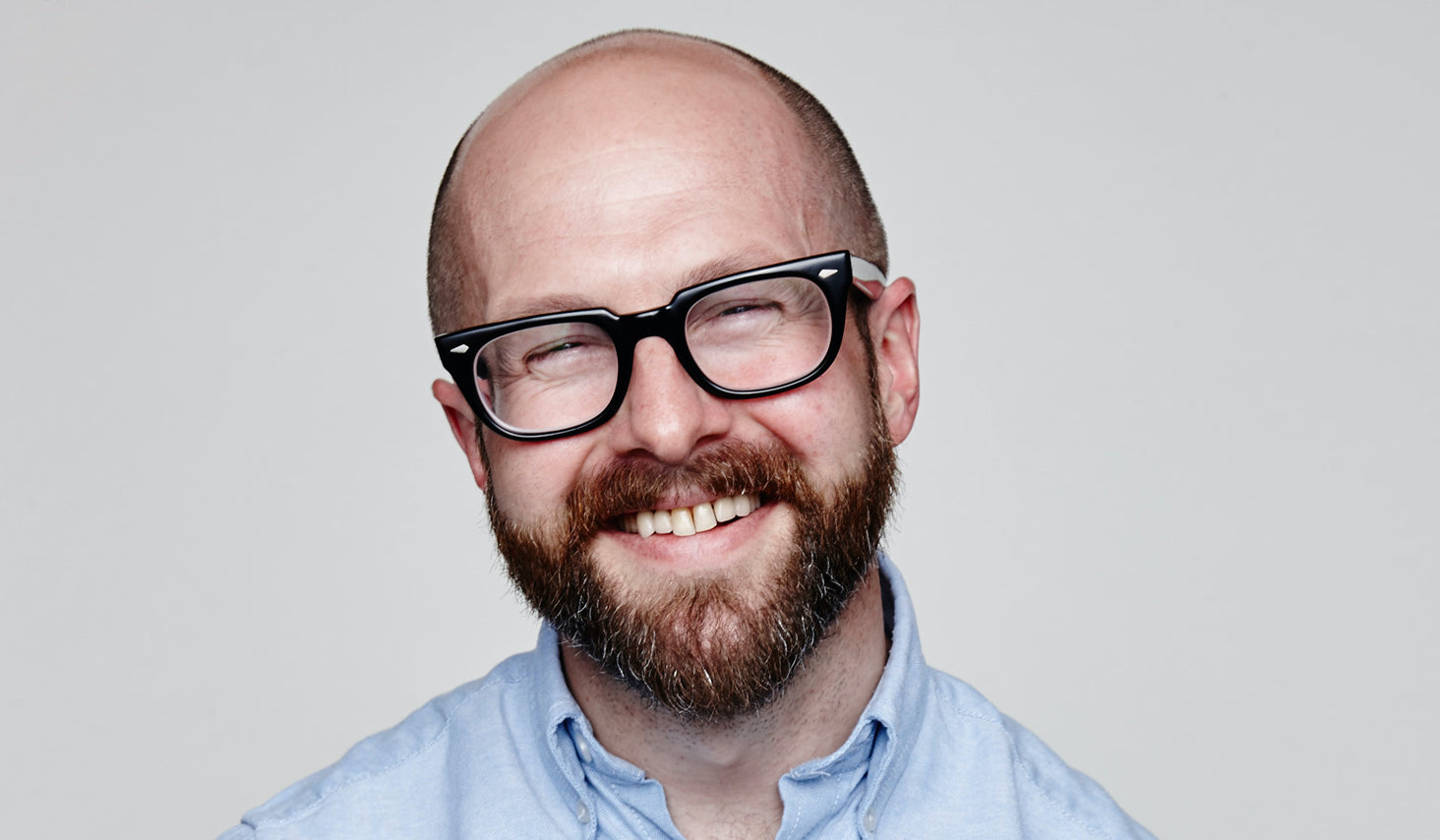Man wearing a blue shirt and glasses.